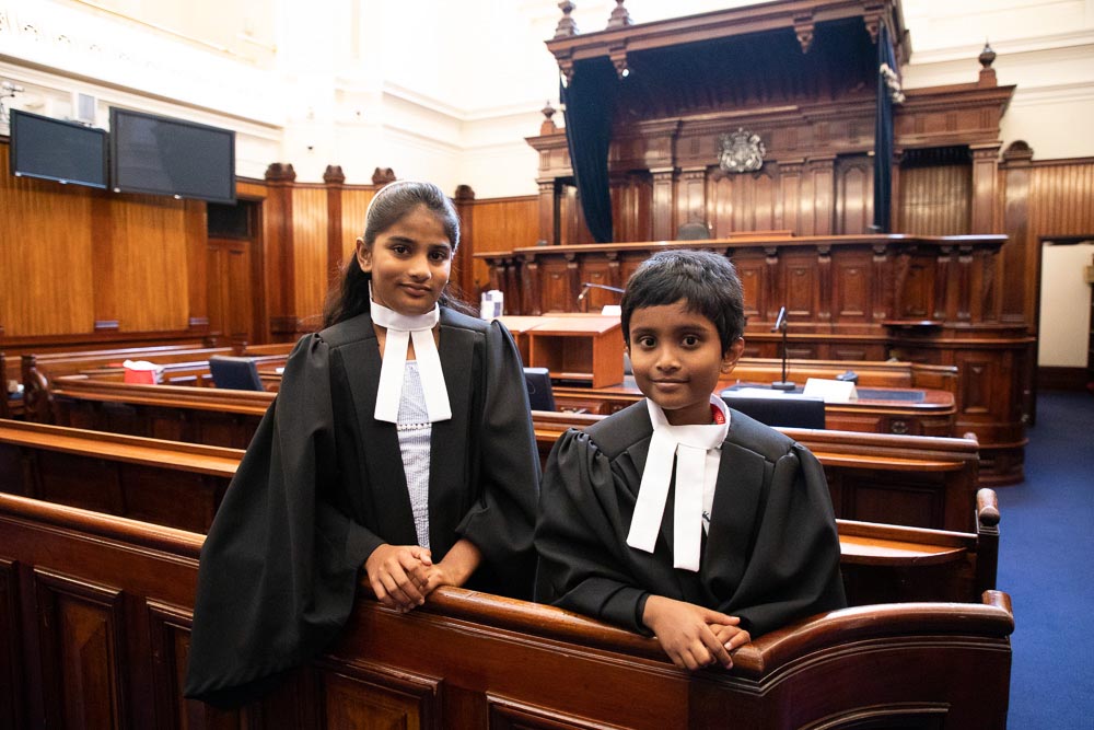 A young girl and a boy pose for a photograph in Court 1 of the Supreme Court during a School Holiday program. 