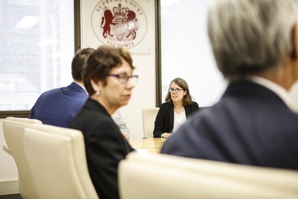 Mediators of the Supreme Court sit around a meeting room table.